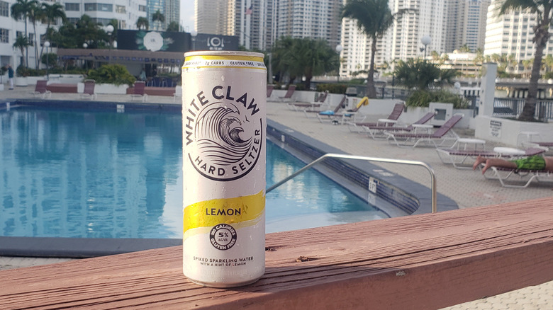 Lemon White Claw can on deck by pool