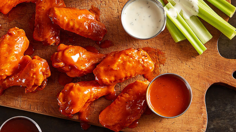 Buffalo wings on a board with sauce