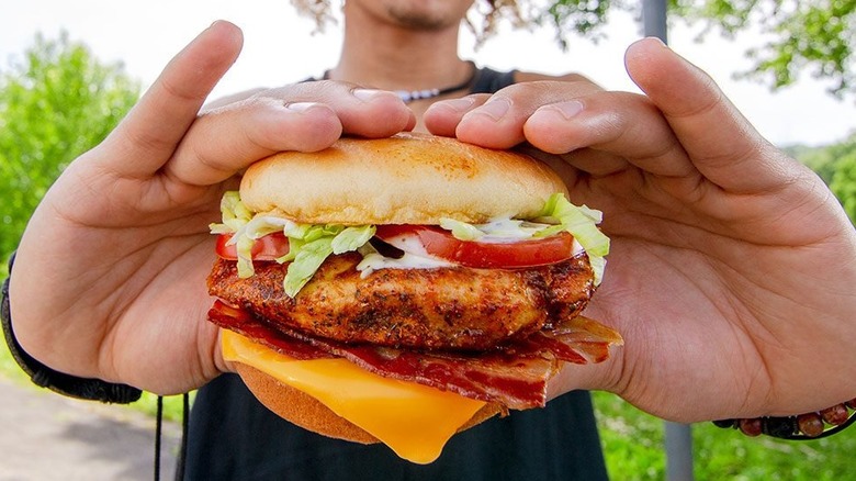 A person holding a chicken sandwich