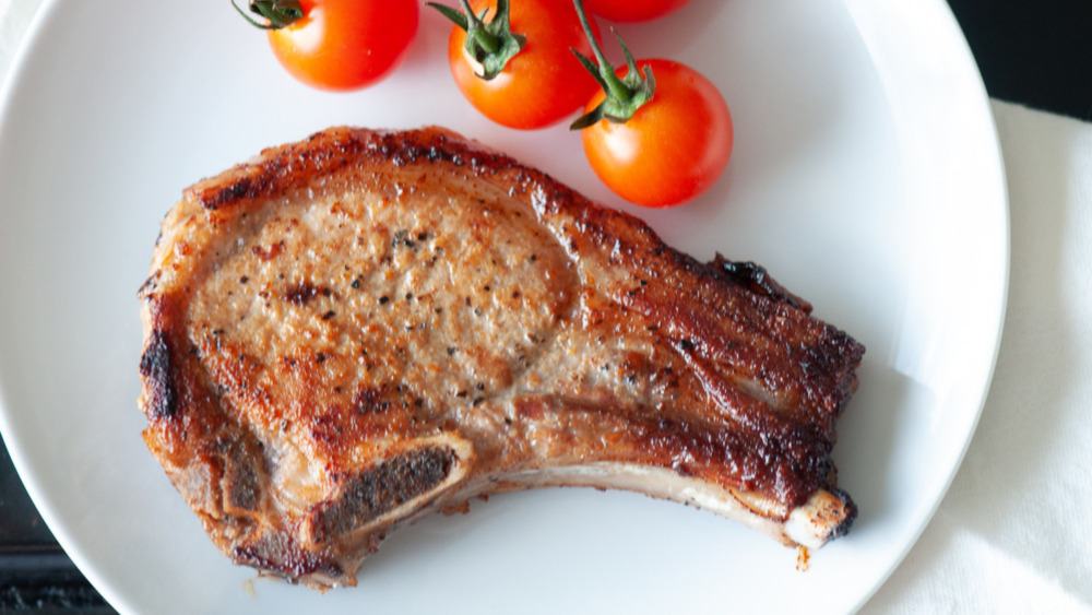 Pork chop on plate with tomatoes