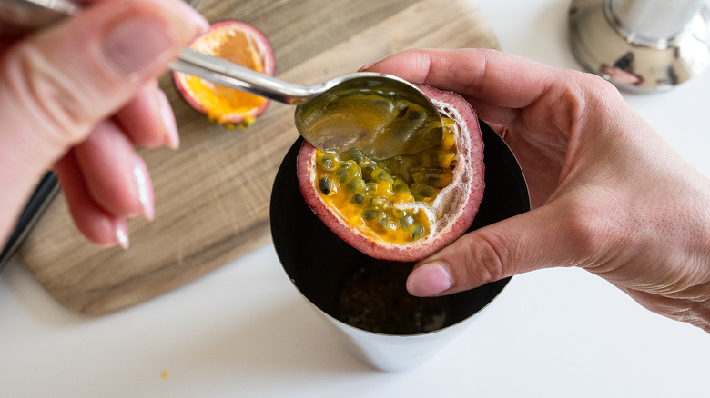 scooping out a passion fruit