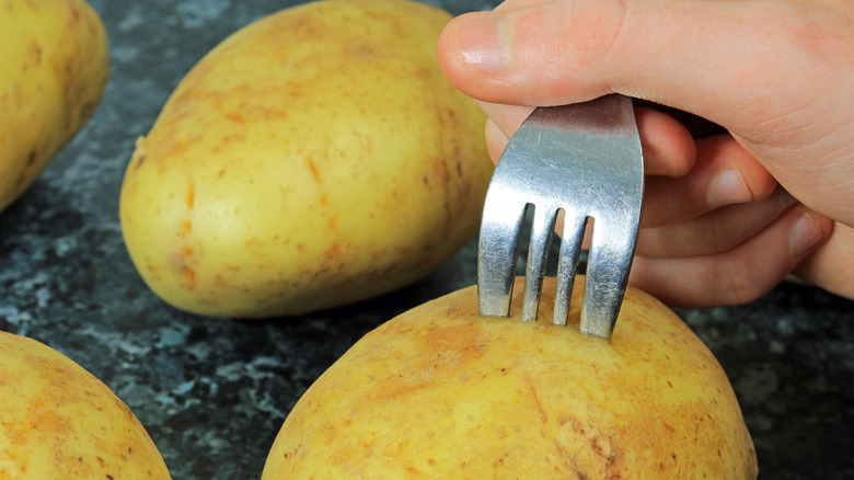 raw potato stabbed with fork