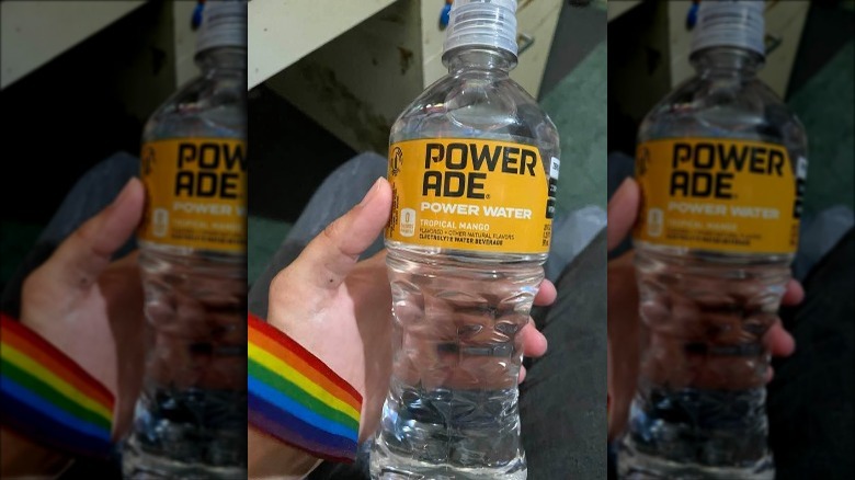 Someone holding bottle of Powerade Power Water Tropical Mango