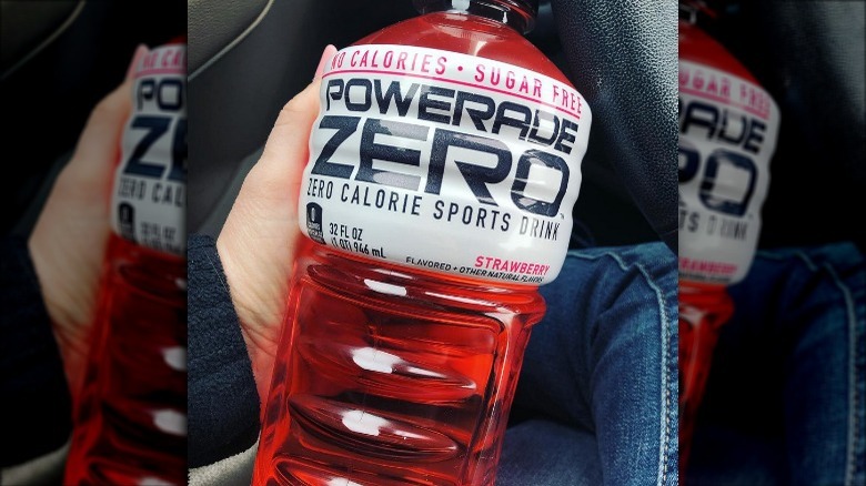 Someone holding Powerade Zero Sugar Strawberry bottle