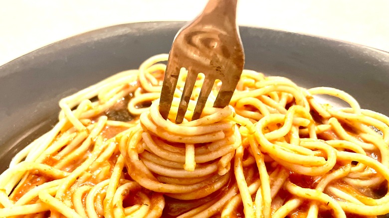 twisting noodles with sauce
