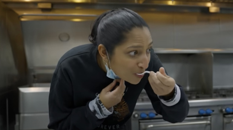 Priya Krishna trying food with plastic spoon