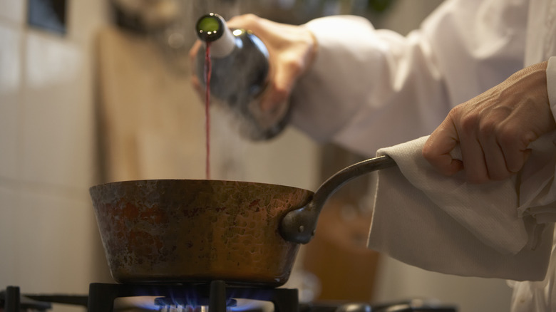 pouring wine into pan