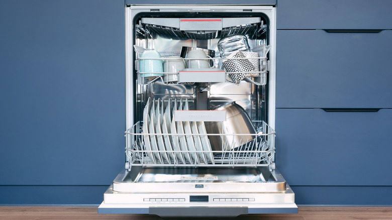 fully loaded open dishwasher in a clean kitchen