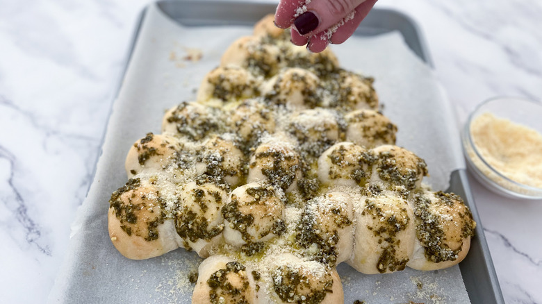 sprinkling toppings on bread 