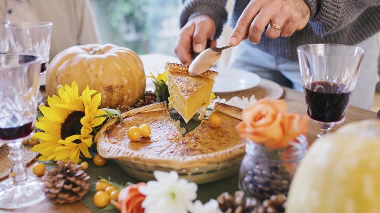 man removing slice of pumpkin pie 