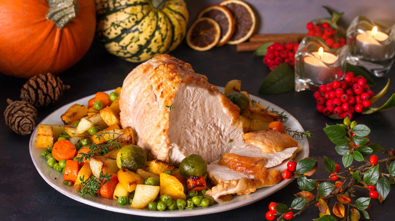 Turkey on a plate with pumpkins in the background