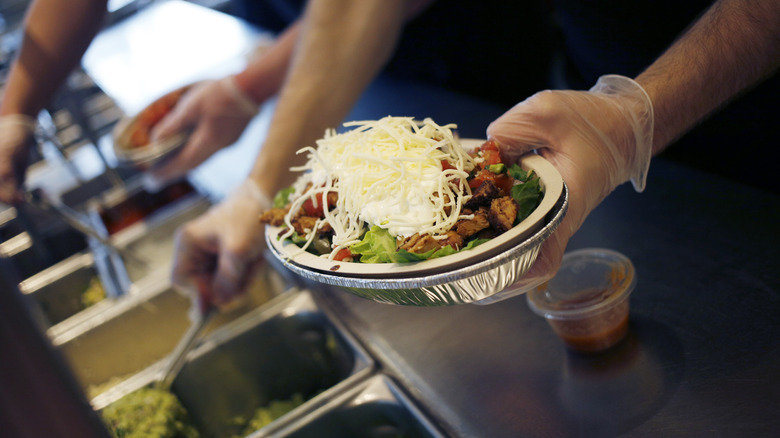 Chipotle employee making a bowl