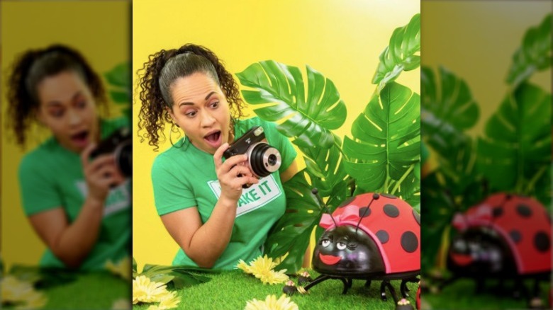 Yolanda Gampp with a camera and a lady bug cake