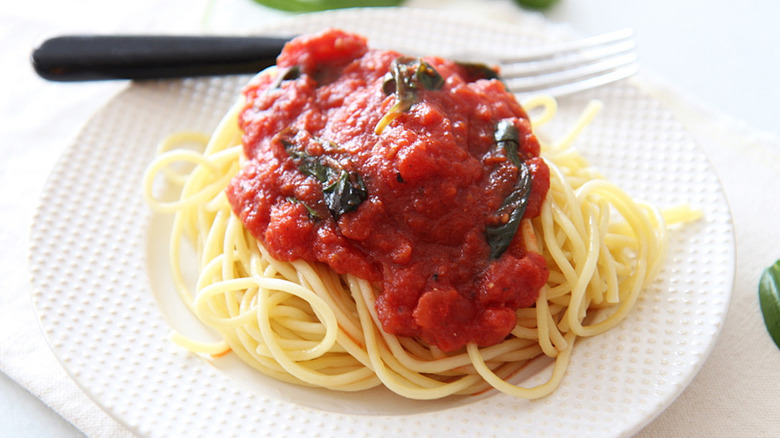 marinara sauce and spaghetti on white plate