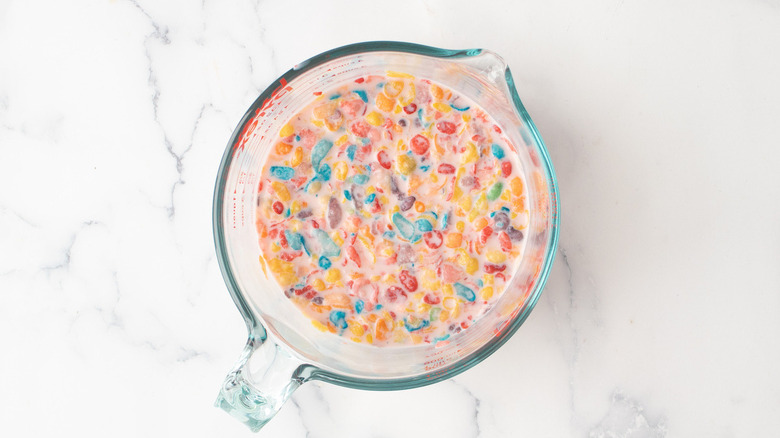 Fruity Pebbles cereal in cup of milk