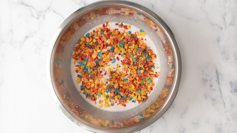 ice cream, milk, and  Fruity Pebbles cereal in a bowl