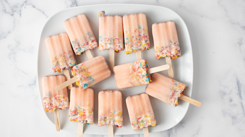 pink popsicles with Fruity Pebbles on a white plate