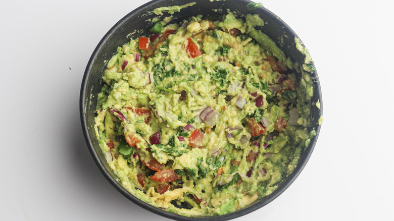 guacamole in black mixing bowl