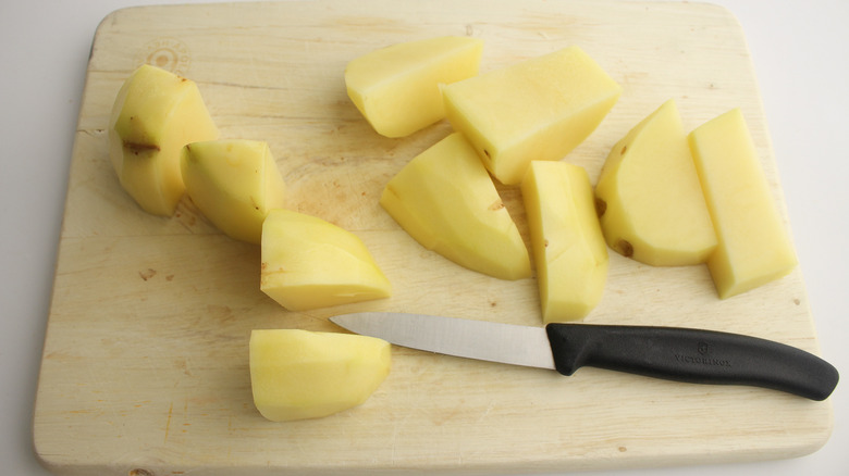 chopped potatoes on cutting board with knife