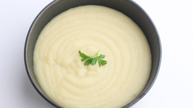 potato soup in bowl with parsley garnish