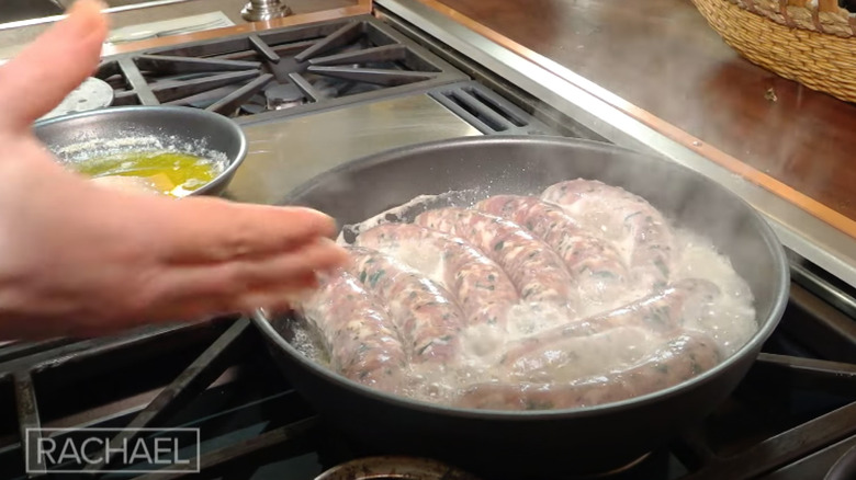 Rachael Ray's sausage cooking in water on stove