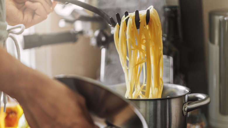 Pulling cooked spaghetti out of the pot