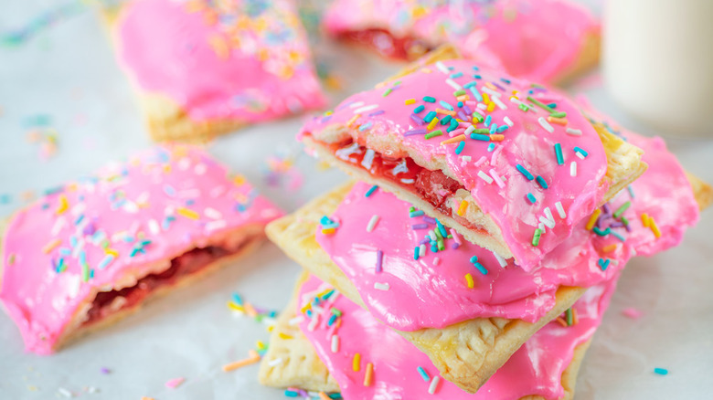 Homemade pop tarts filled with cherry preserves and topped with pink frosting and rainbow sprinkles