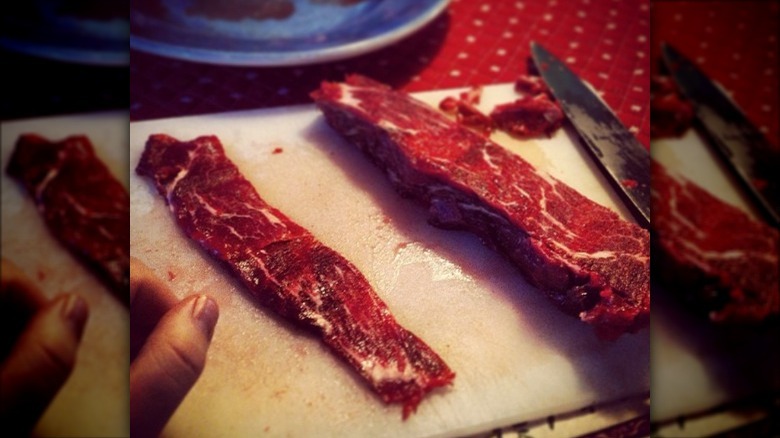 Person slicing sirloin for beef jerky