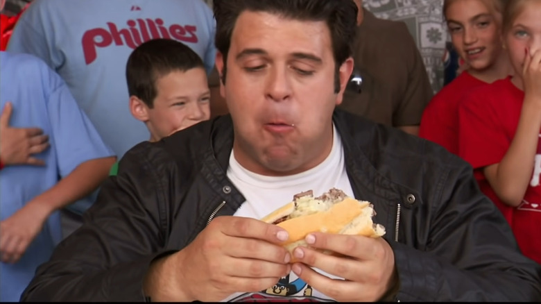 Adam Richman eating a cheesesteak