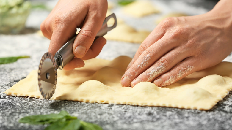 cutting a fresh sheet of ravioli