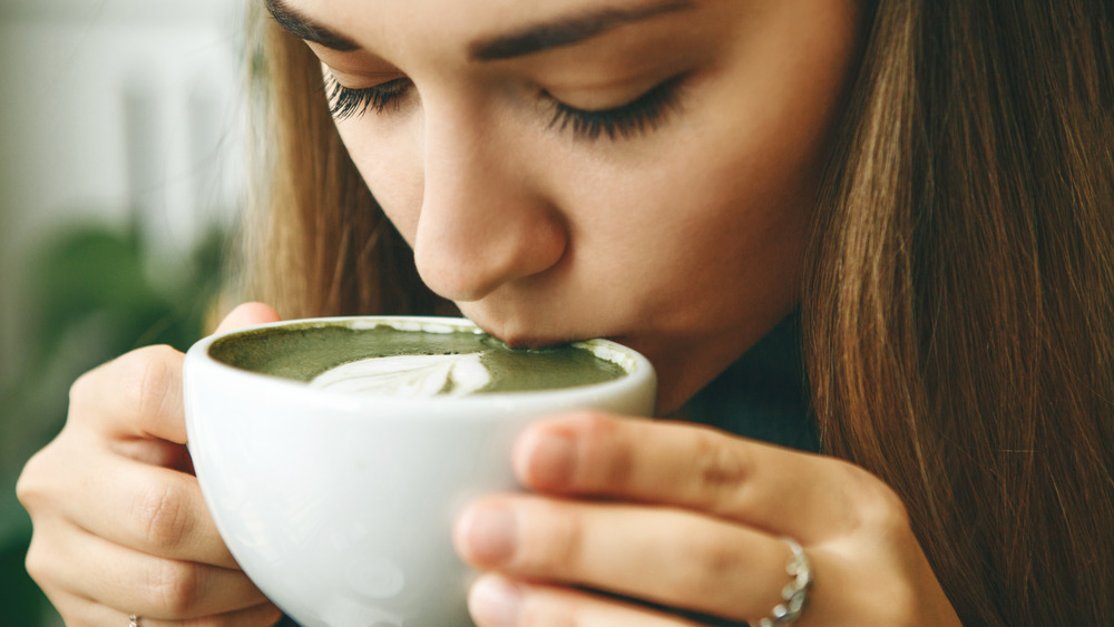 Woman sipping a matcha latte