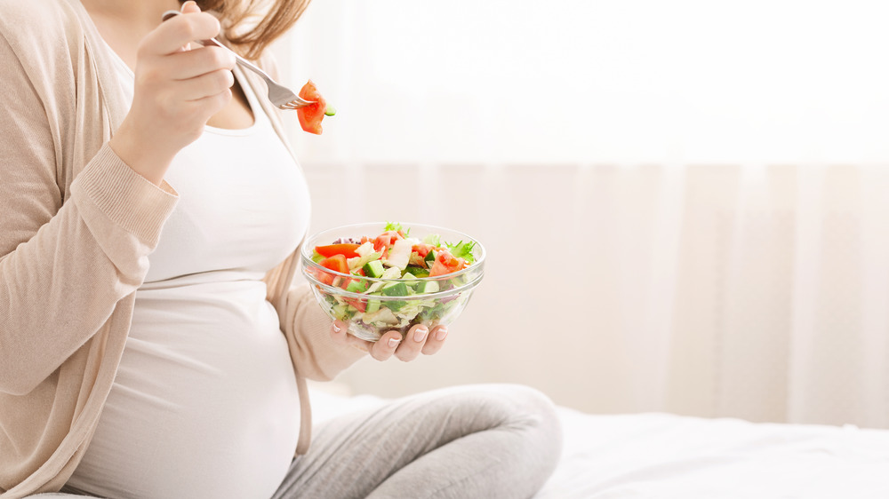 Pregnant woman eating steak