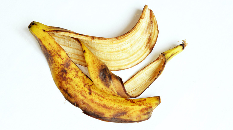 Black, brown and yellow banana peel on a white background