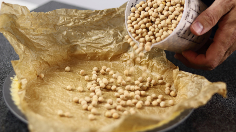 Adding beans to pie pan