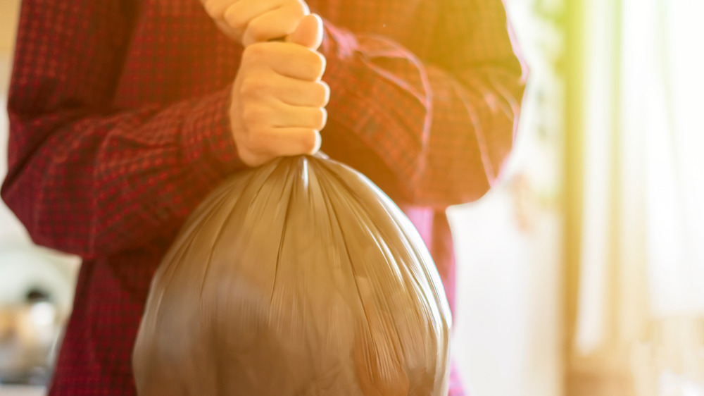 Person carrying trash bag