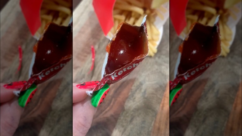 Dipping a french fry into a ketchup packet