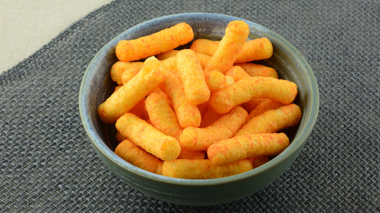 A bowl of cheese puff snacks 