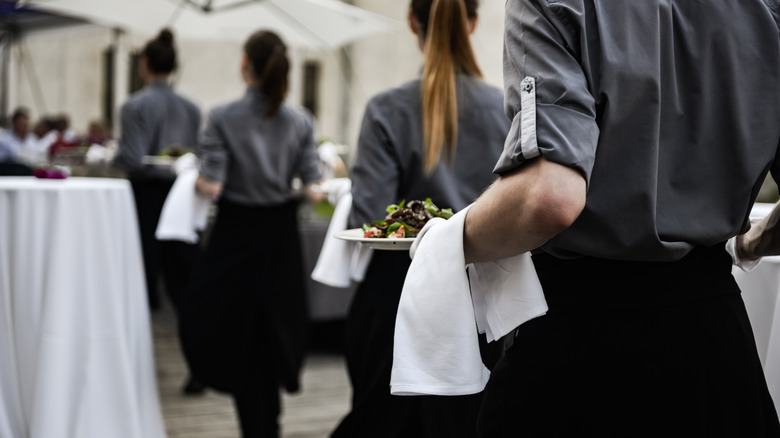 steakhouse employees carrying entrees 