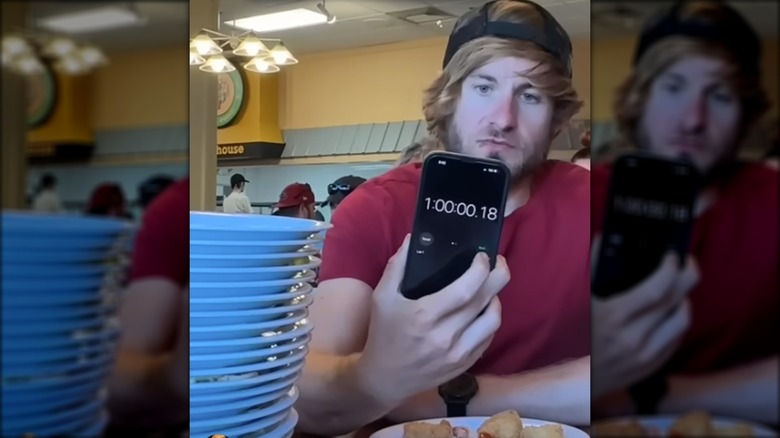 man with stacked plates at buffet