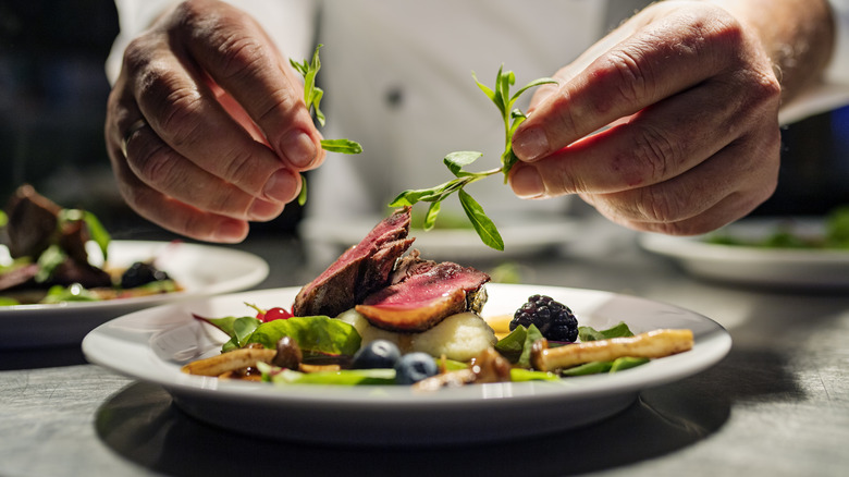 chef placing garnish on food