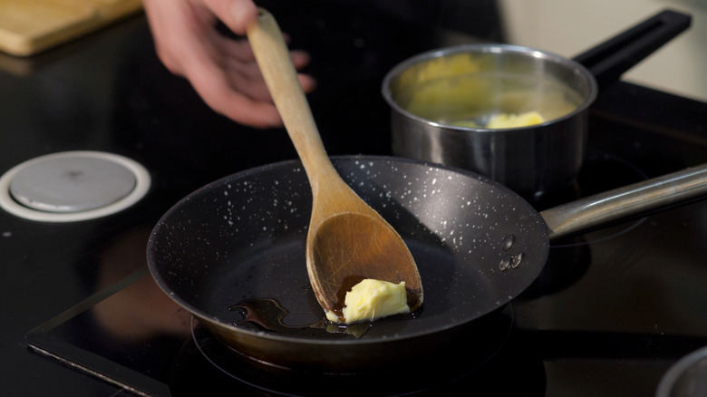 chef melting butter in skillet