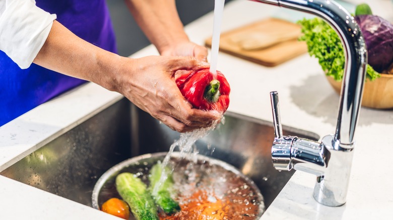 chef washing red bell pepper 