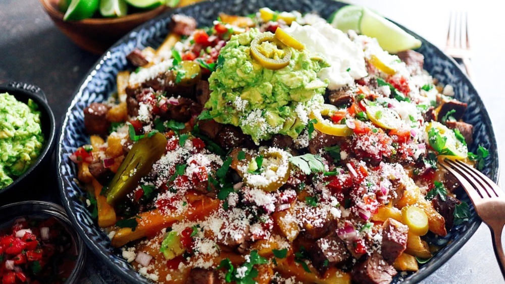 A heaping bowl of carne asada fries and a fork.