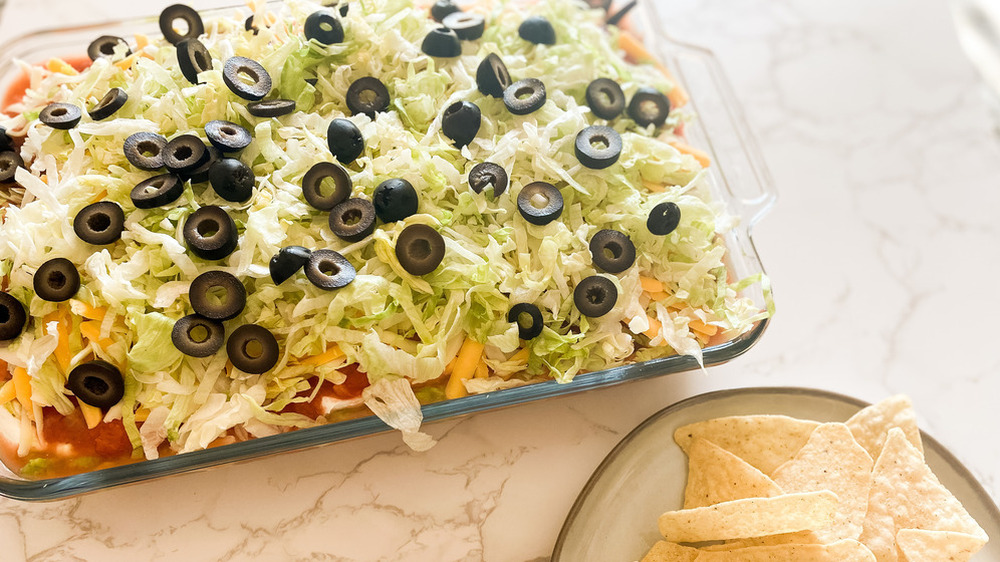 Dip covered in lettuce and olives 