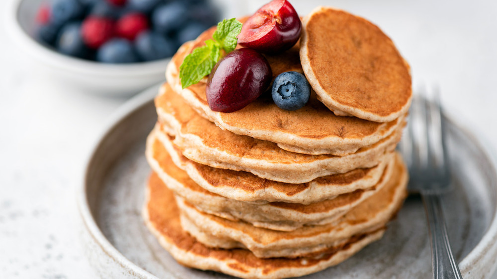 Pancakes topped with cherries, blueberries, and mint