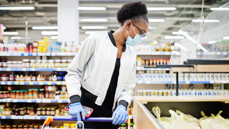 Woman shopping in grocery store with a medical face mask