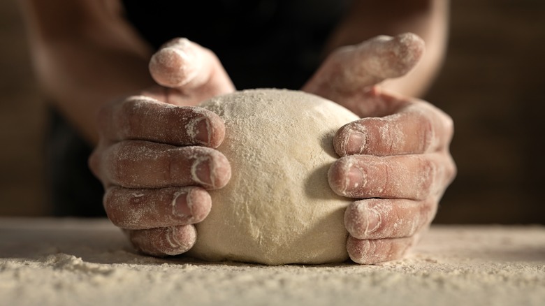 chef hands holding pizza dough