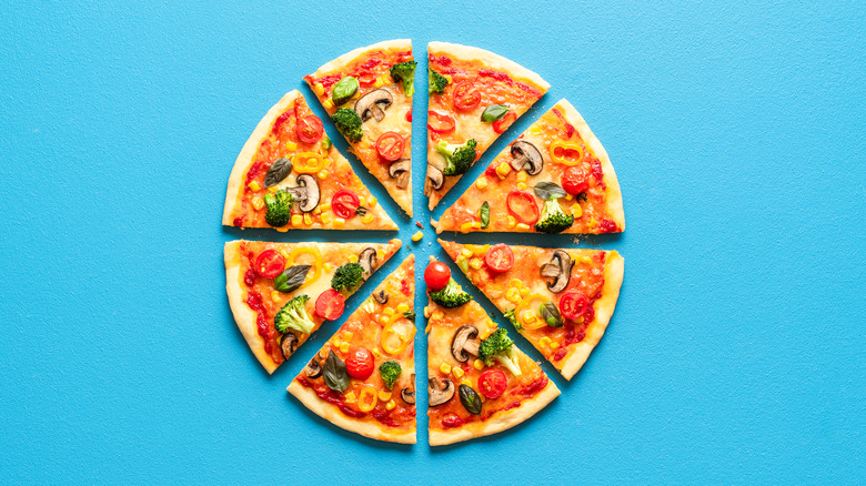 veggie pizza cut into slices on blue background