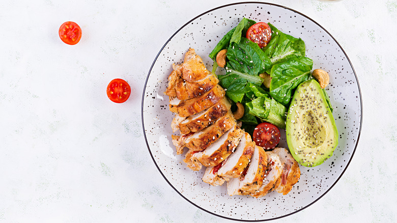 Deconstructed salad with chicken, lettuce, and avocado 