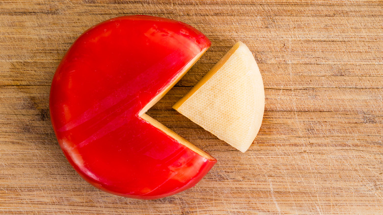 wheel of gouda cheese with wedge cut out